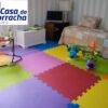 Quarto infantil com tapetes coloridos e brinquedos.