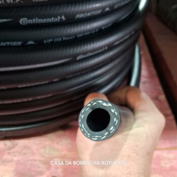 Mangueira de borracha preta enrolada, com foco na extremidade que mostra o interior.