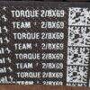 Texto em uma superfície escura com as palavras 'TORQUE' e 'TEAM' repetidas