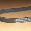 Correia preta da marca Continental, modelo 6 PK 1220, em fundo marrom.