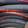 Mangueiras de combustível da marca Continental empilhadas, mostrando rótulos com especificações técnicas.