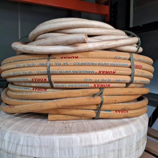 Bobinas de mangueira de vapor empilhadas em um suporte.